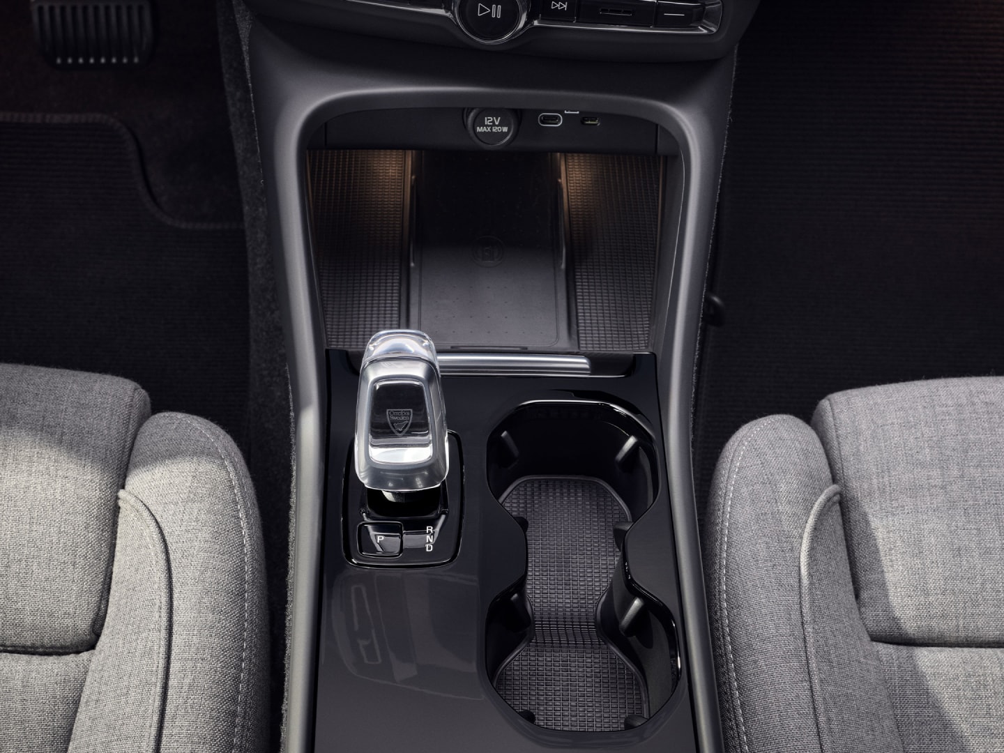 A tisztán elektromos Volvo EC40 első ülései között elhelyezett pohártartó, sebességváltó és vezeték nélküli töltő.