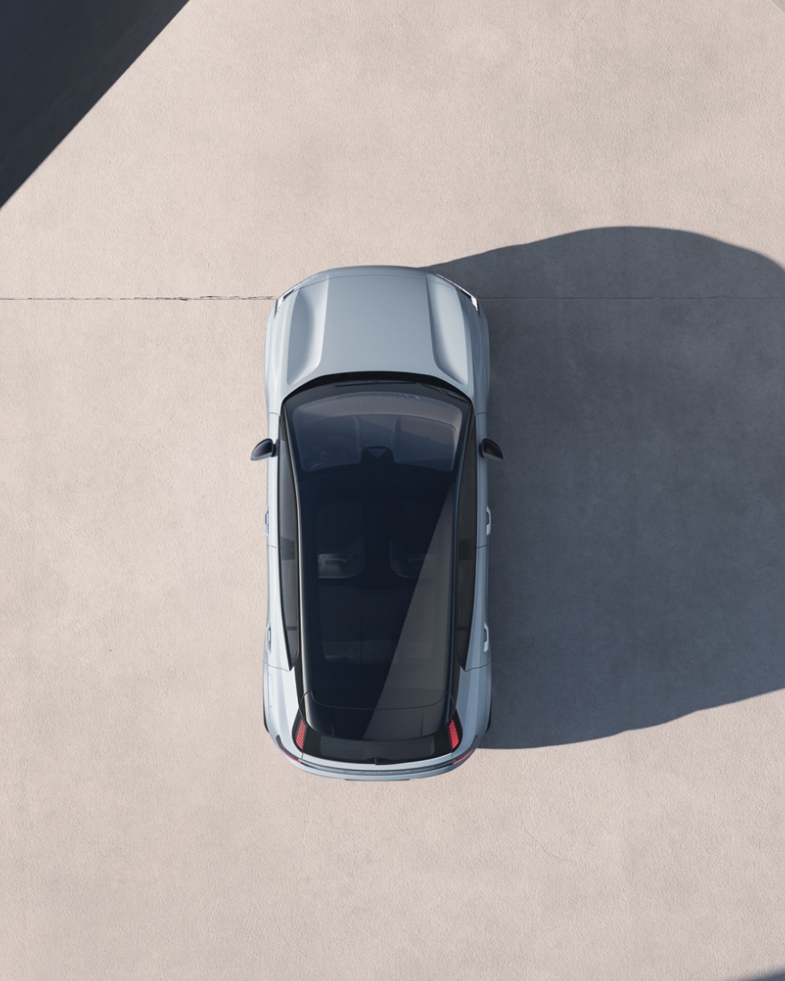 Vedere de sus asupra unui Volvo EX30 iluminat puternic din lateral, proiectând o umbră lungă.