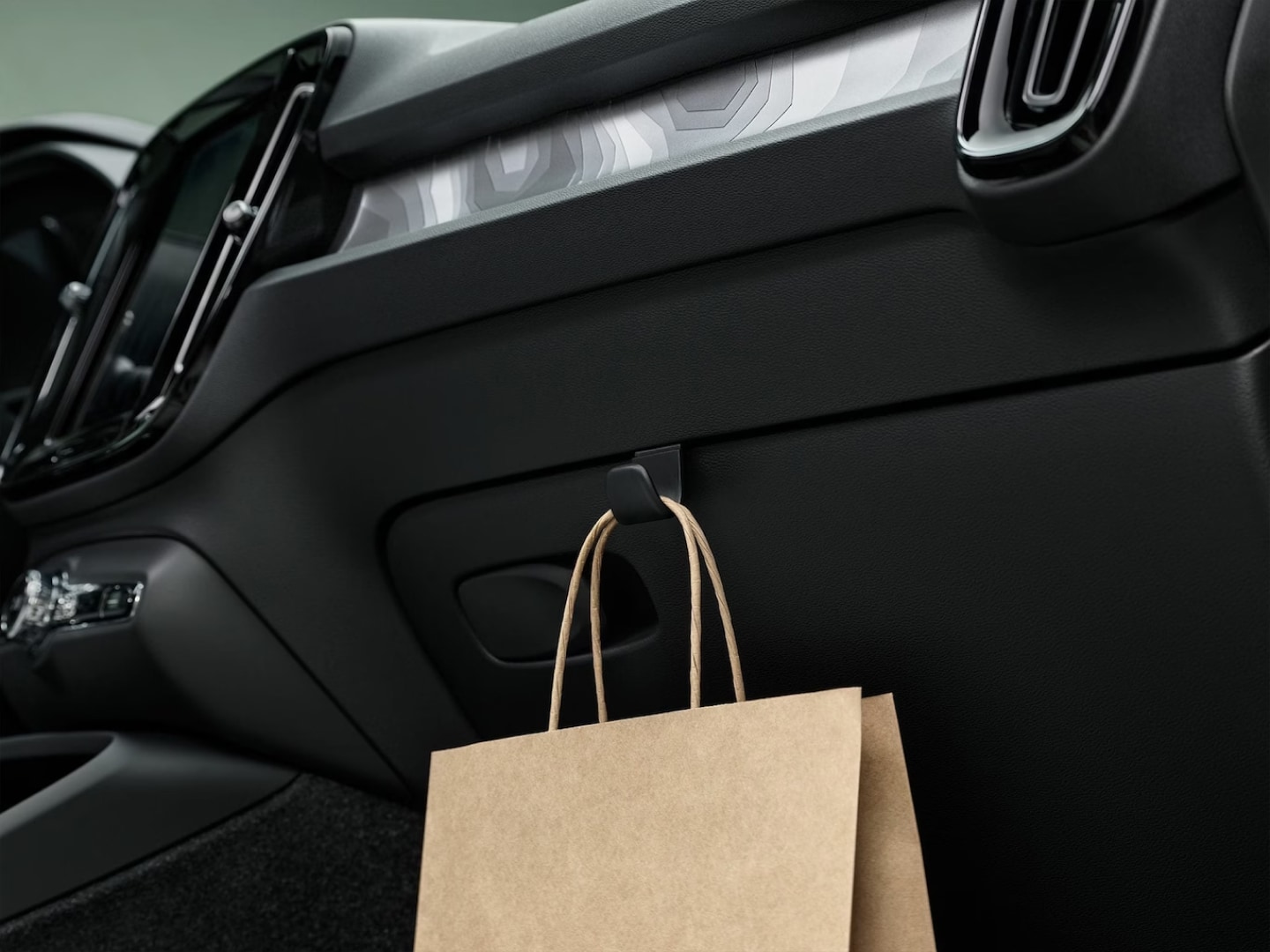 Un discreto gancho en el habitáculo del Volvo EX40 sujeta una bolsa de papel.