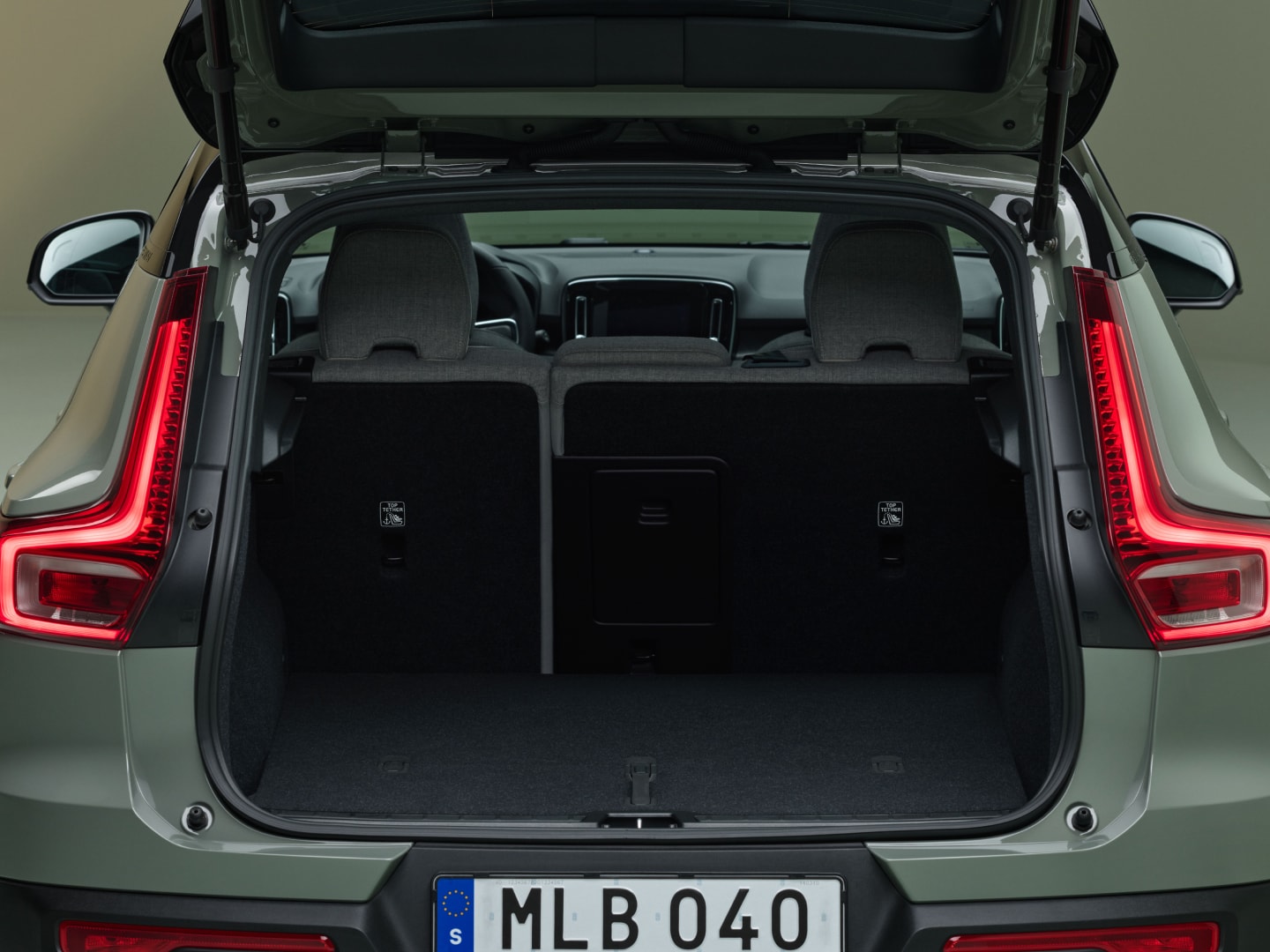 Die geöffnete Heckklappe des Volvo EX40 gibt den Blick auf einen geräumigen und breiten hinteren Laderaum frei.