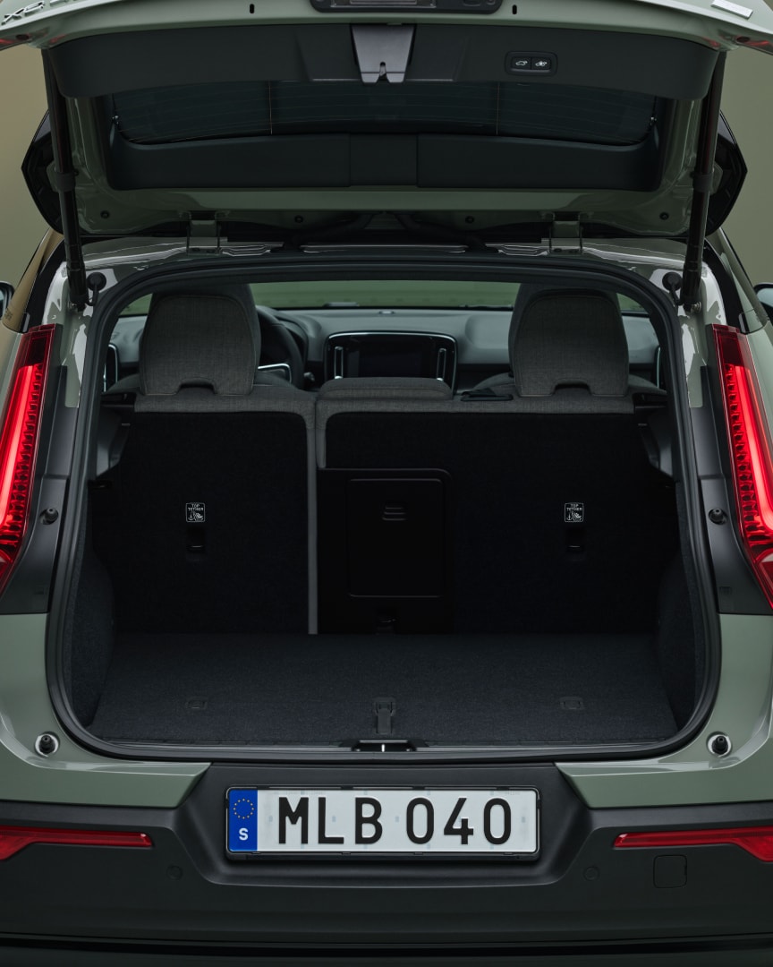 The open tailgate of the Volvo EX40 reveals a spacious and wide rear load compartment.