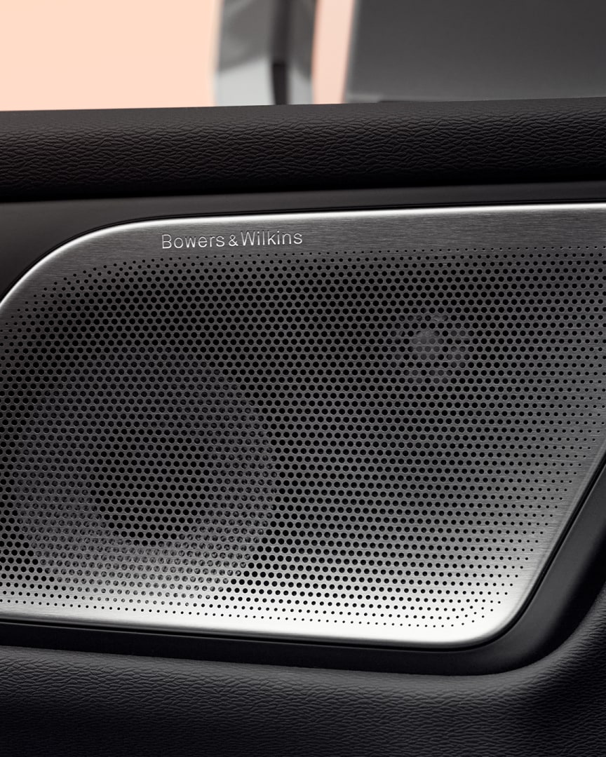 Zbliżenie na głośnik Bowers & Wilkins w drzwiach i elementy sterujące pasażera w miękkiej hybrydzie Volvo V60