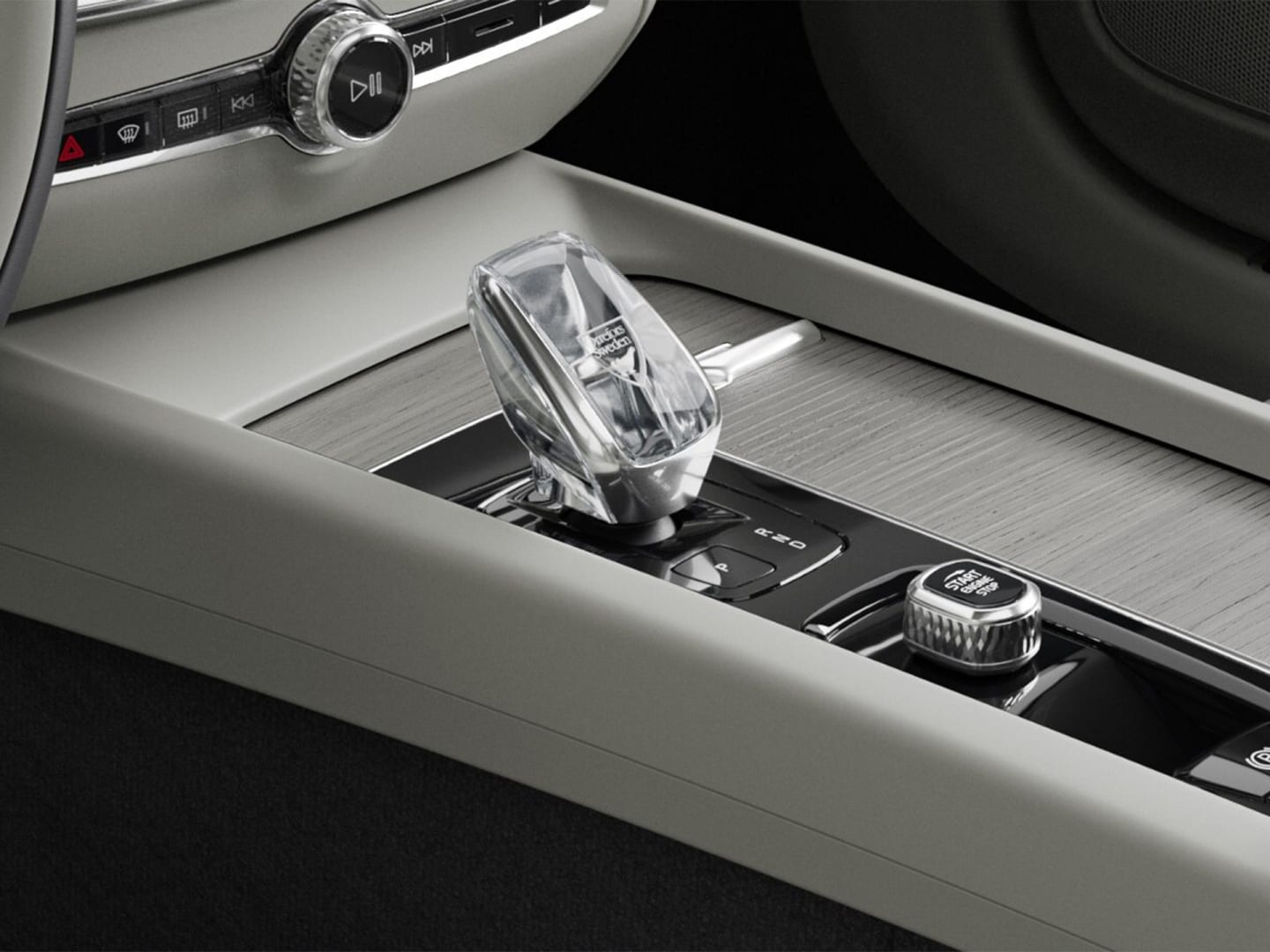 Botón de arranque y palanca de cambios de cristal en la consola central con acabados en madera del semihíbrido Volvo V60.