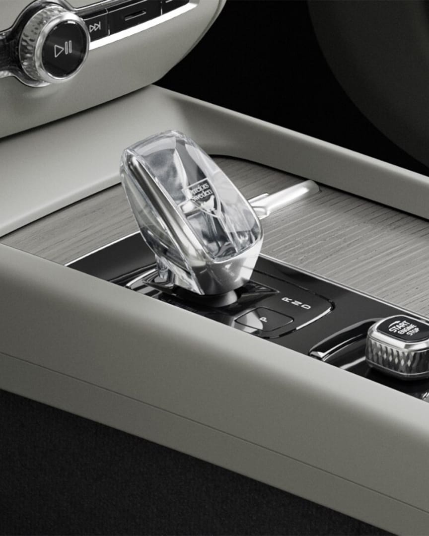 Bouton de démarrage et levier de vitesse en cristal dans la console centrale ornée de bois de la Volvo V60 Mild Hybrid.