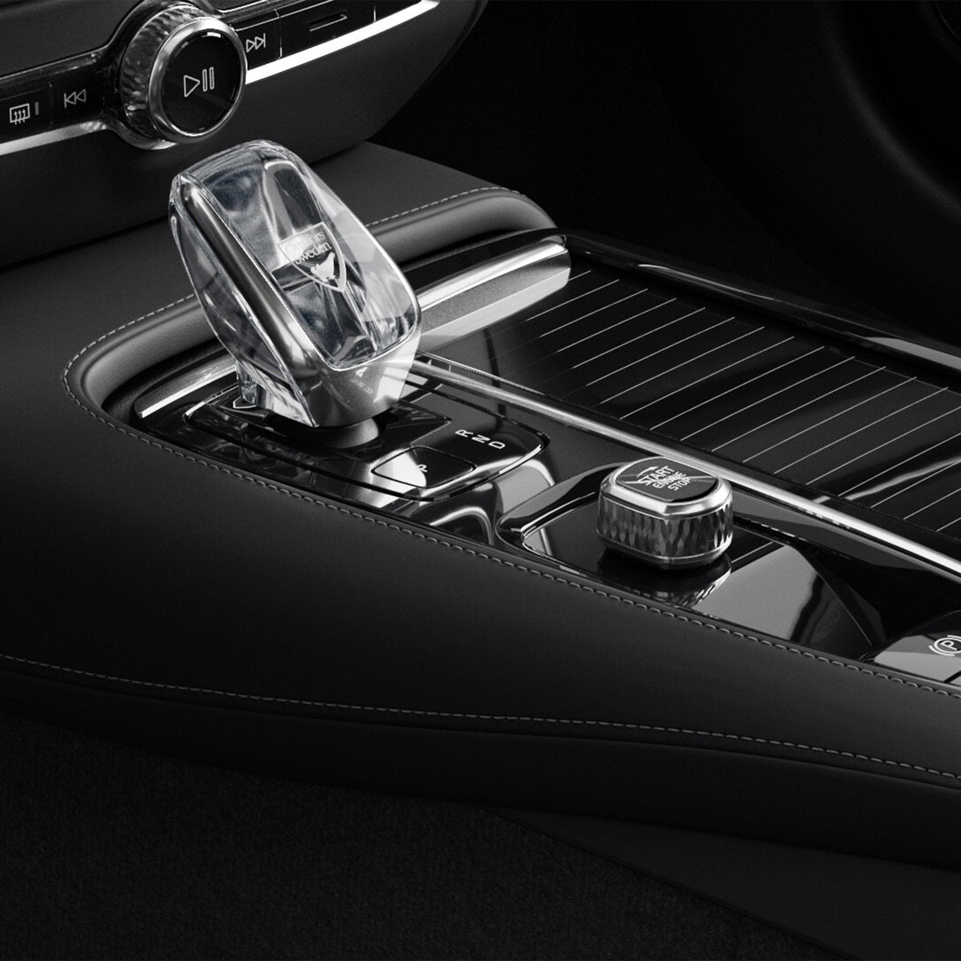 Botón de arranque y palanca de cambios de cristal en la consola central del Volvo V60 híbrido enchufable.