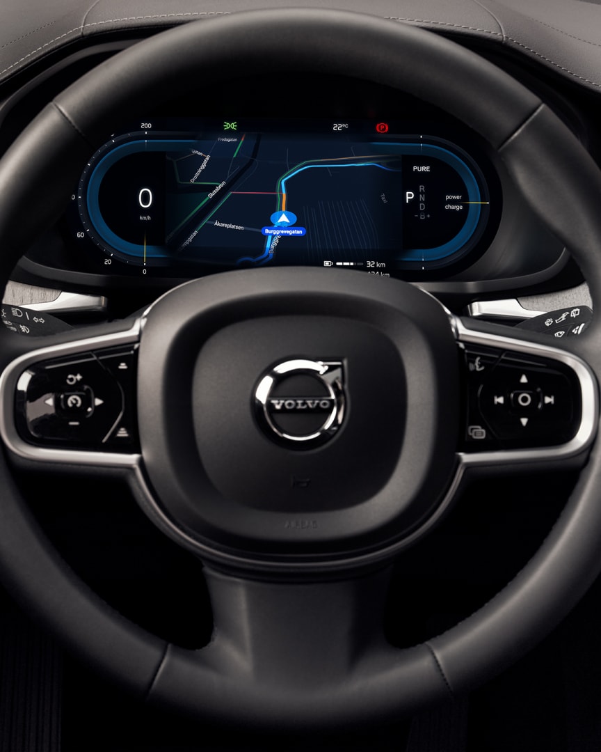Blick des Fahrers auf das Lenkrad, die Instrumententafel und den Infotainment-Touchscreen des Volvo V60 Plug-in Hybrid.
