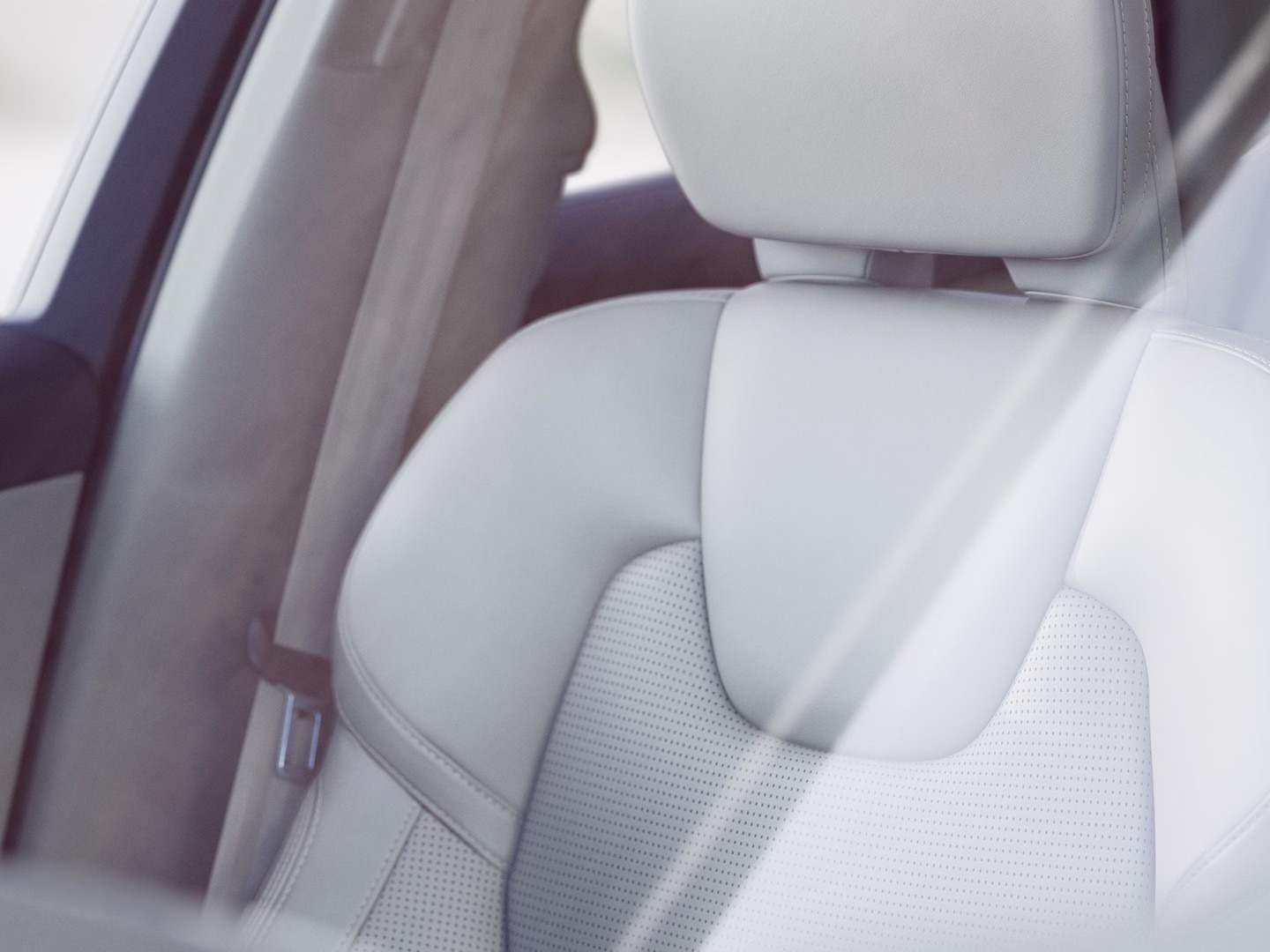 Pohled zblízka na přední sedadlo čalouněné kůží v interiéru vozu Volvo XC60.