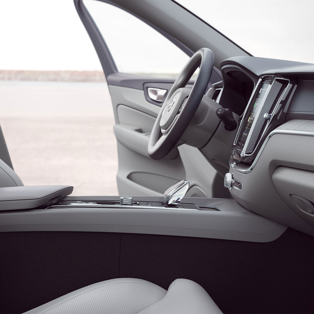 Přední část interiéru plug-in hybridního vozu Volvo XC60 s otevřenými dveřmi řidiče.