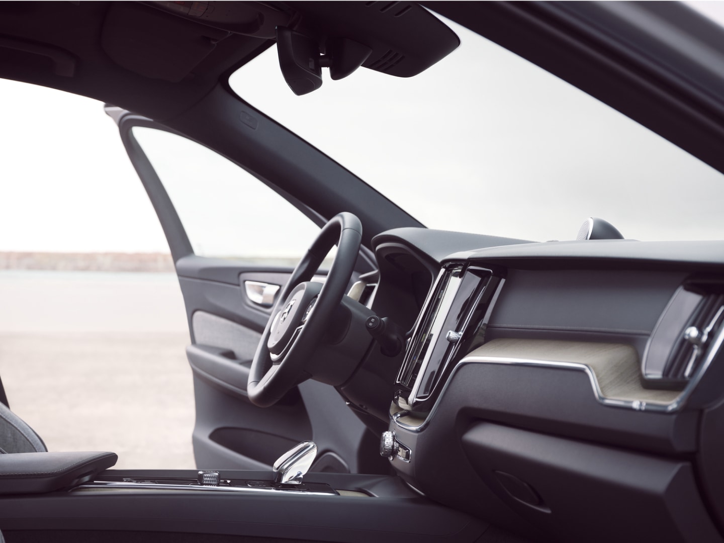 Predná časť interiéru plug-in hybridného vozidla Volvo XC60 s otvorenými dverami vodiča.