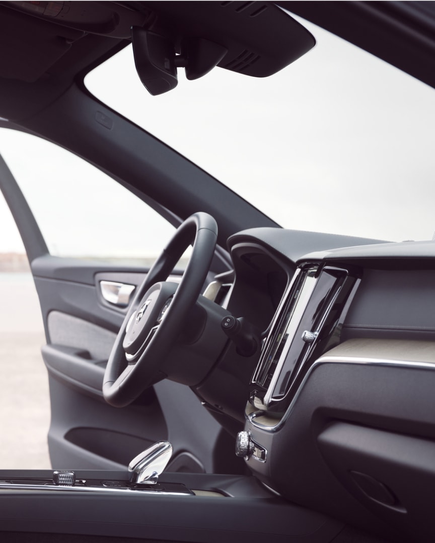 Vorderer Innenraum eines Volvo XC60 Plug-in Hybrid mit geöffneter Fahrertür.