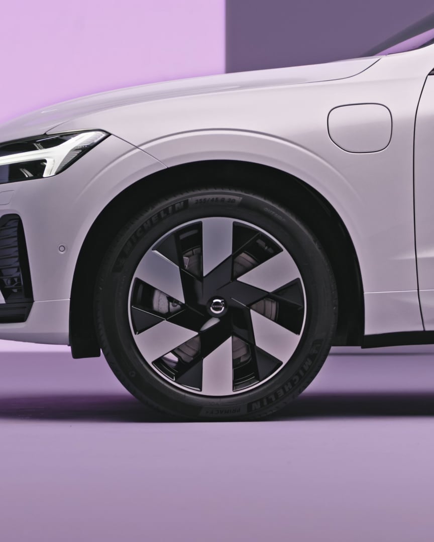 Sidovy av en Volvo XC60 laddhybrid som visar bilens hjul och front.