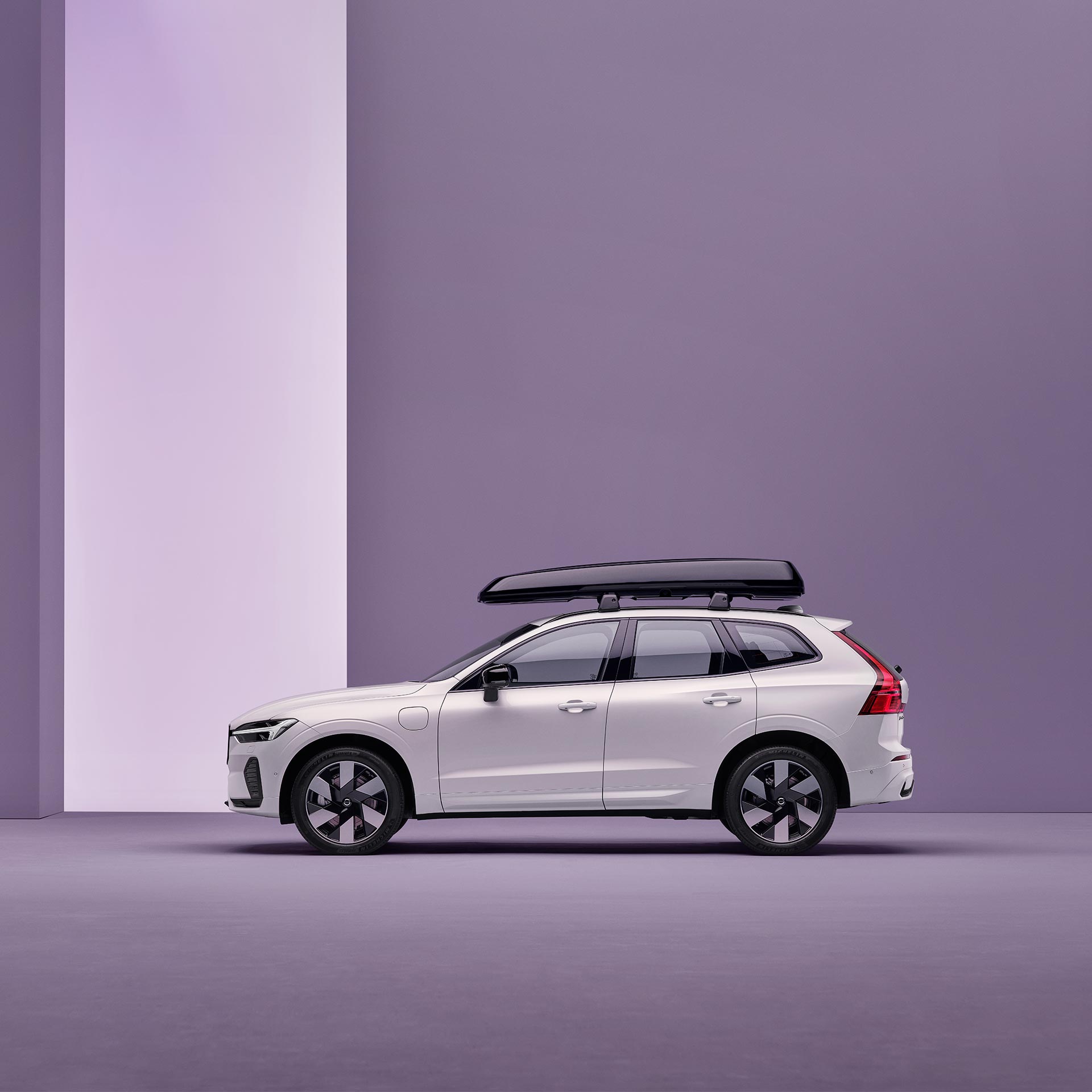 Side view of a Volvo XC60 plug-in hybrid with a roof box.