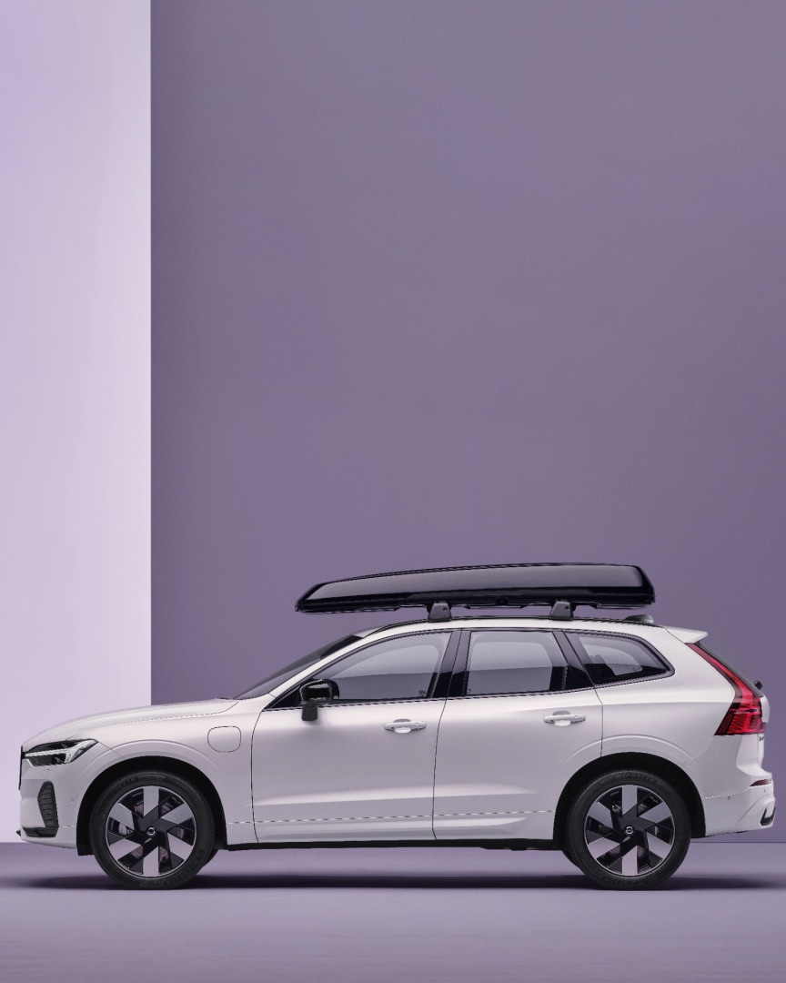 Side view of a Volvo XC60 plug-in hybrid with a roof box.