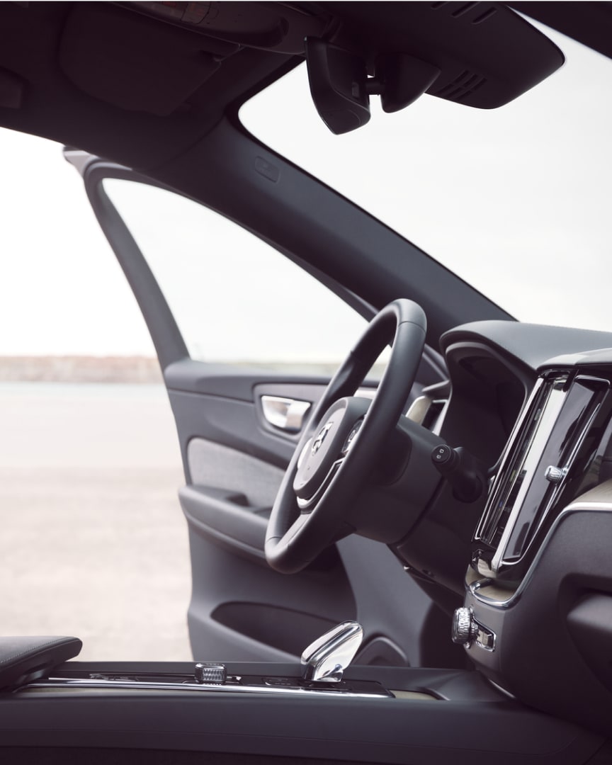 Interior frontal del Volvo XC60 híbrido enchufable con la puerta del conductor abierta.