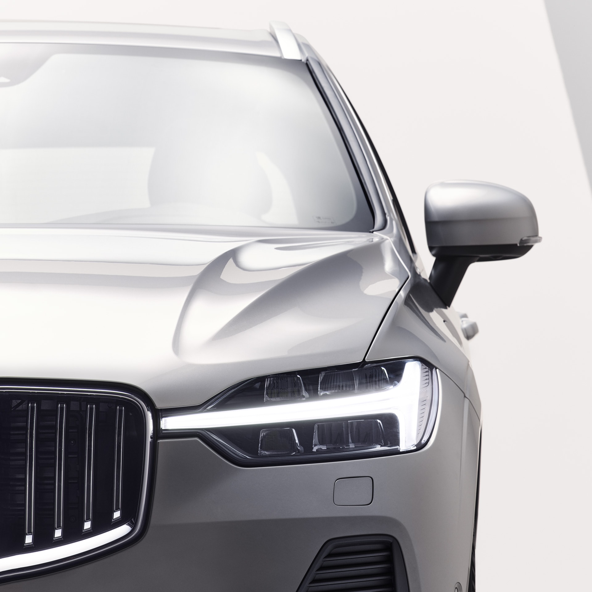Front exterior of Volvo XC60 plug-in hybrid with the iconic front grille and headlamp design.