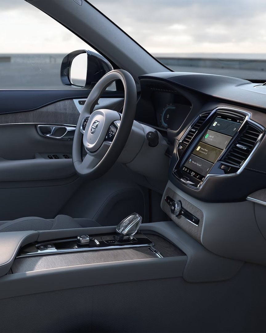 Sedadlo řidiče čalouněné kůží nappa, dekorativní obložení dveří, volant, středová konzola a dotykový displej infotainment systému v mild hybridním voze Volvo XC90.