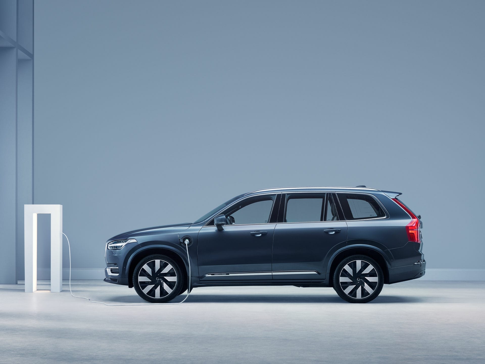 The side profile of a Volvo XC90 plug-in hybrid SUV.