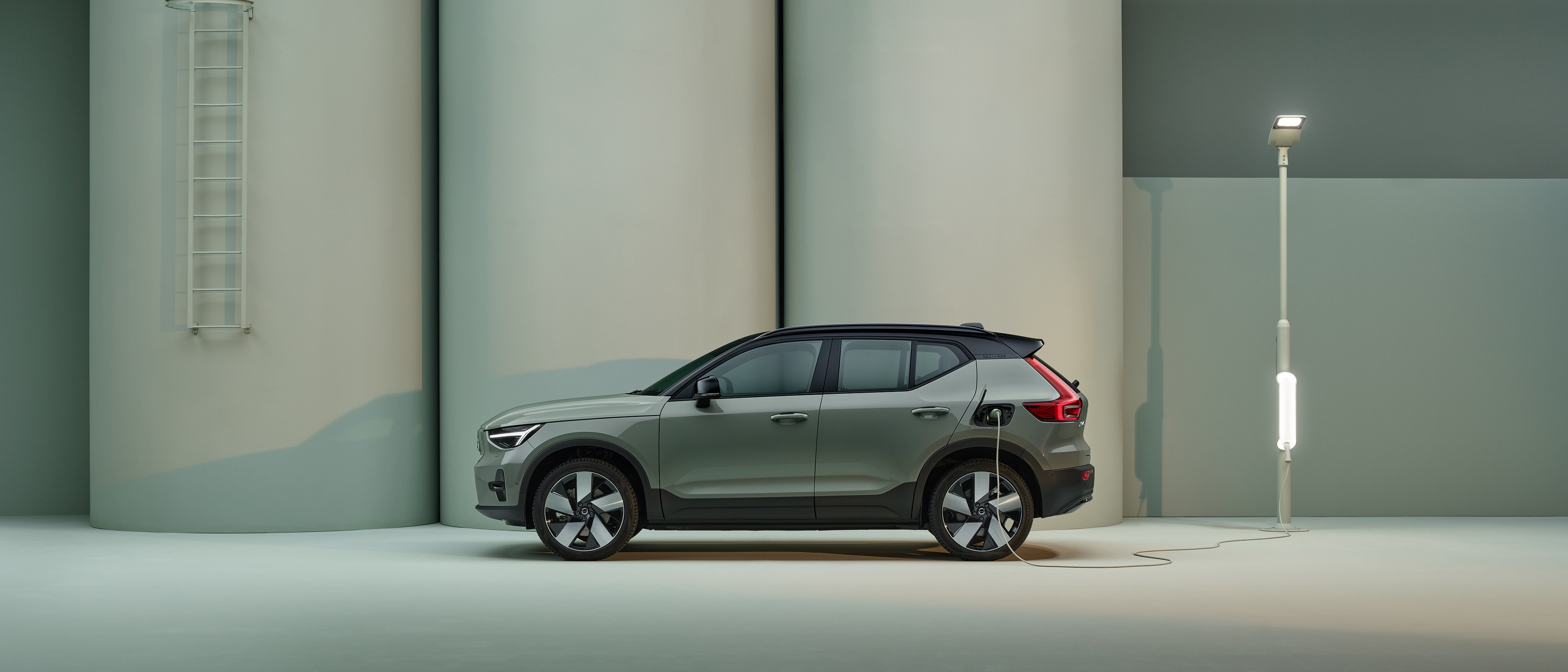 The side profile of a green Volvo XC40 Recharge pure electric SUV.