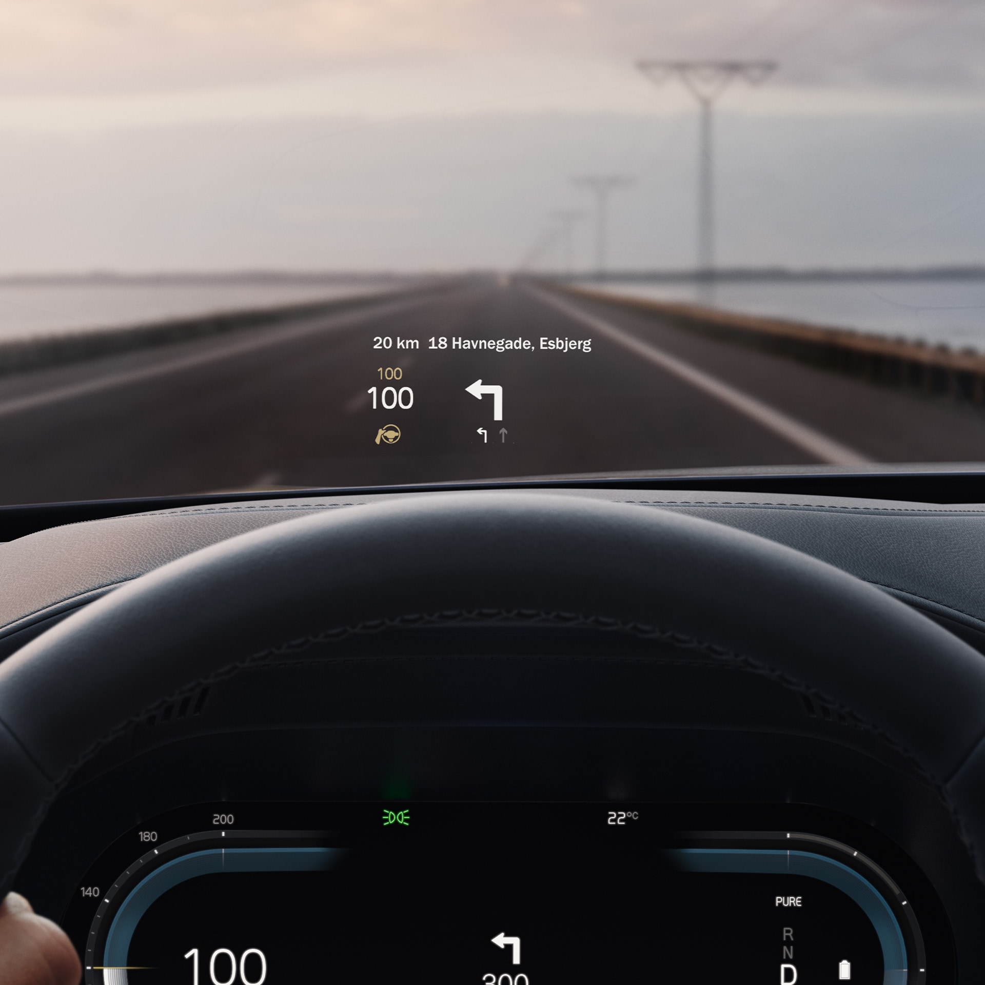 Inside a Volvo, head-up display showing driving speed and navigation on the windshield. 