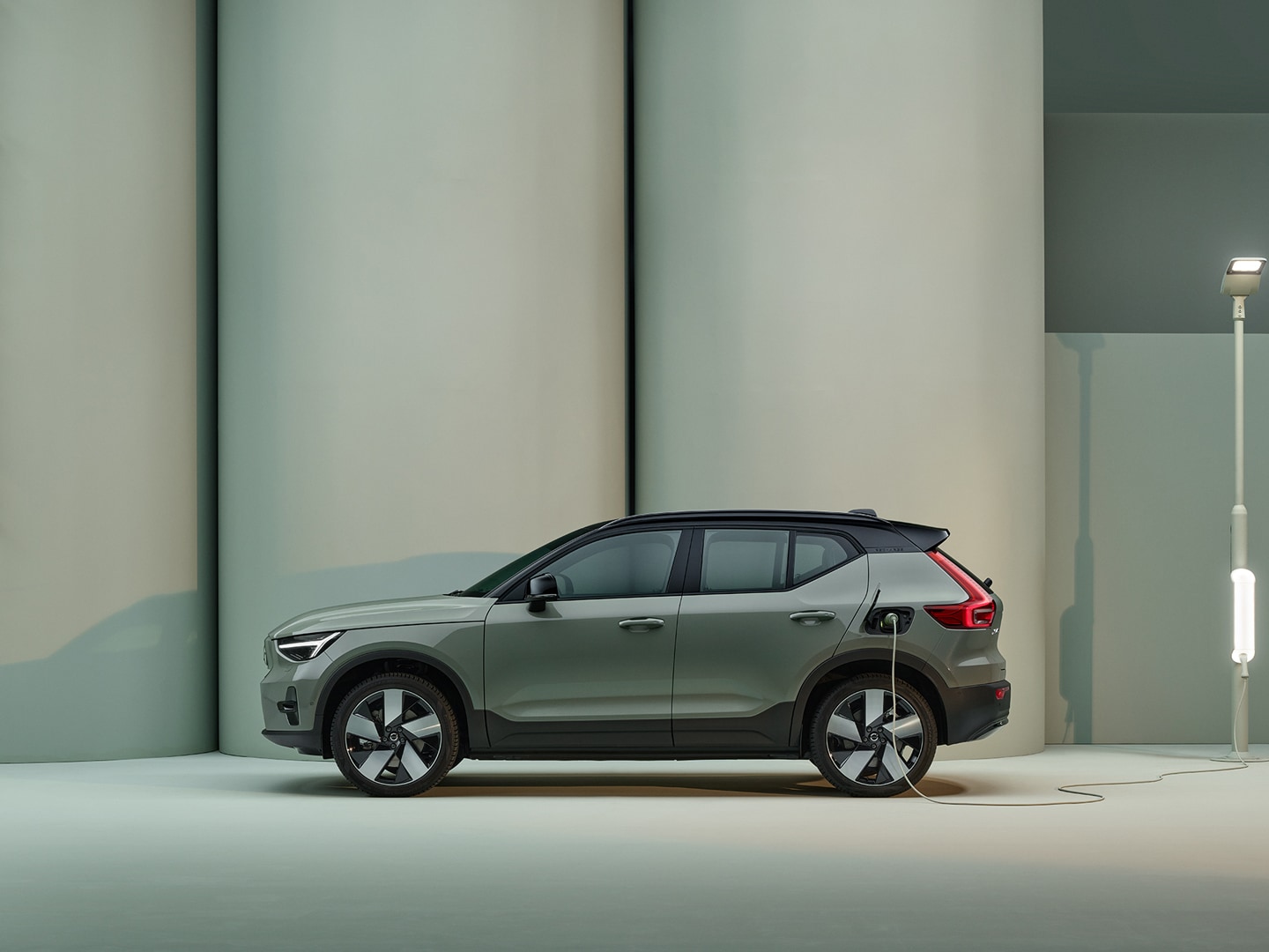 A white Volvo XC40 Recharge electric SUV charged in a pink city