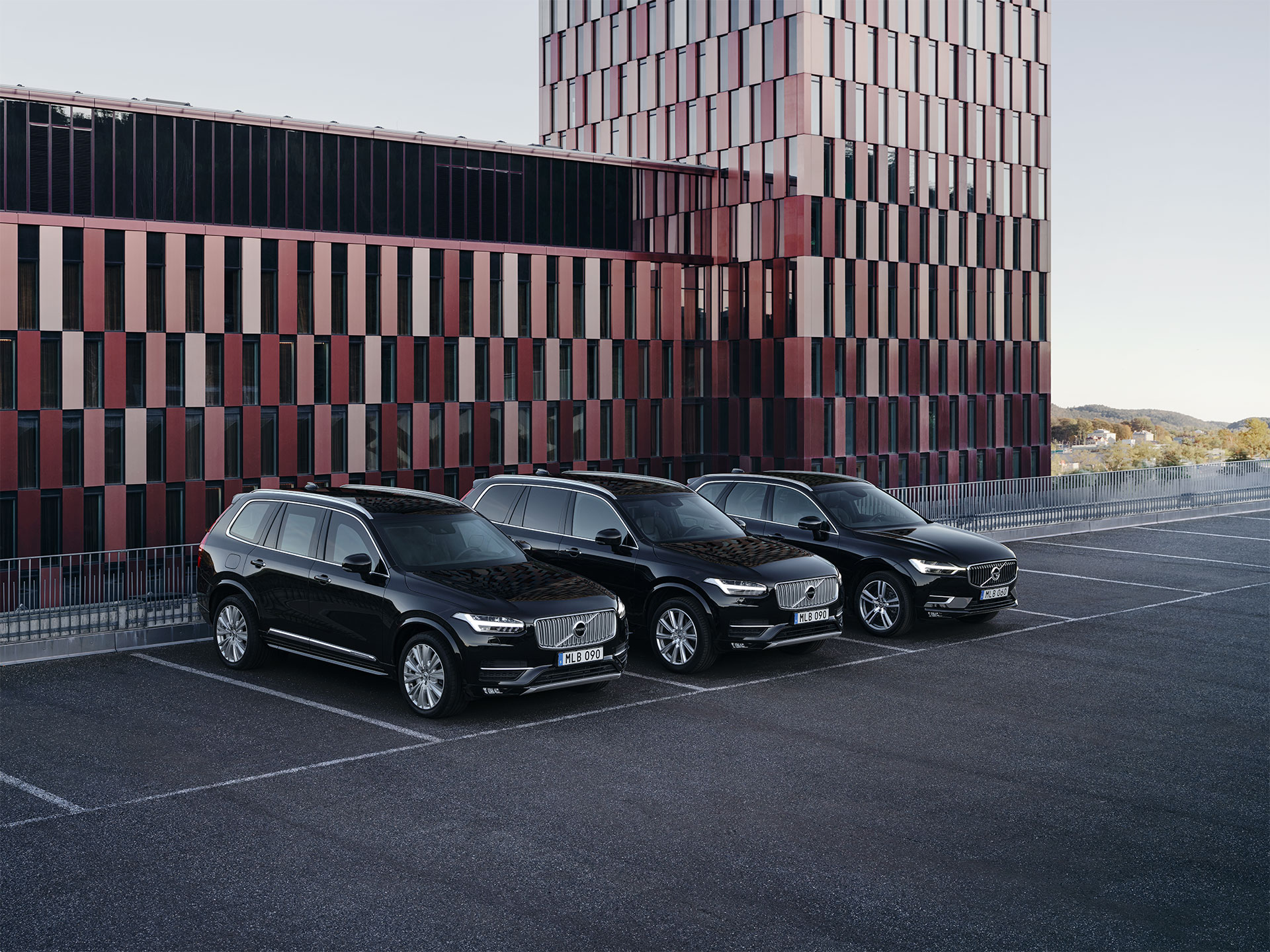 Den tungt bepansrade Volvo XC90 och de lätt bepansrade XC90 och XC60 parkerade utanför en officiell byggnad.