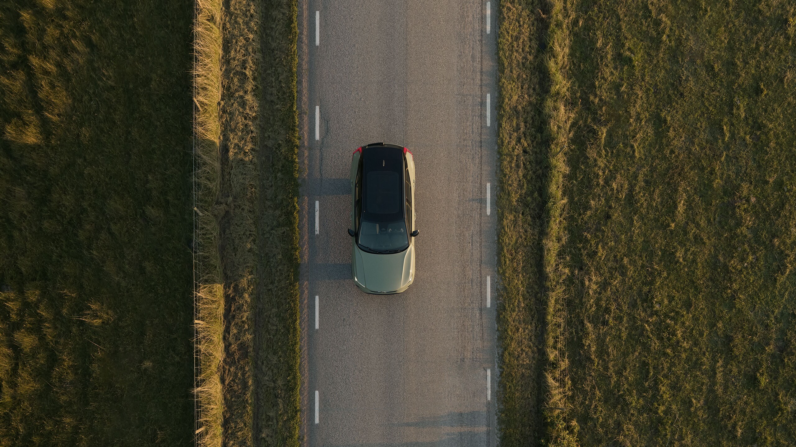 Een elektrische Volvo rijdt op een plattelandsweg.