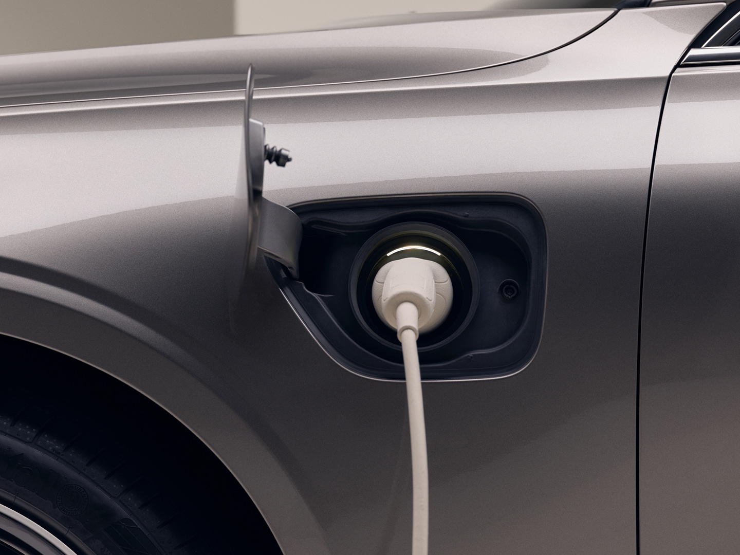 Um close-up de um cabo de carregamento conectado à porta de carregamento de um carro Volvo Recharge.