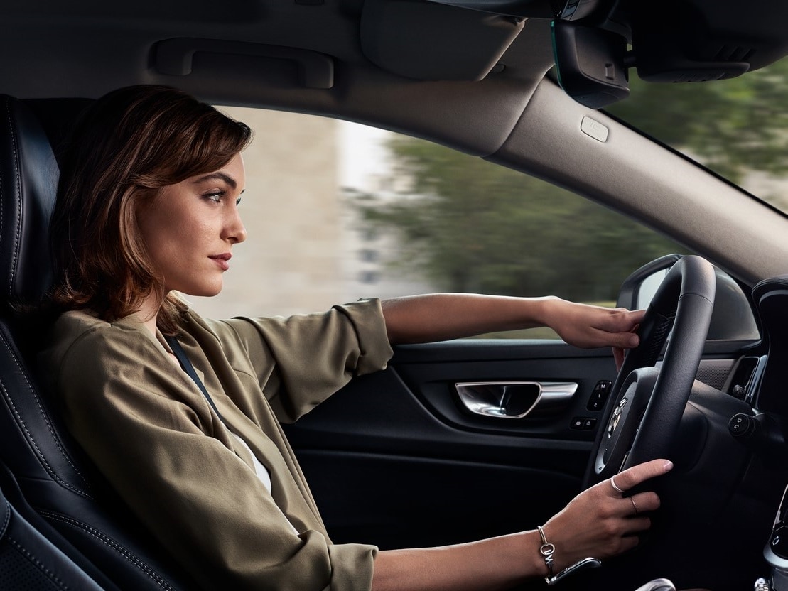A lady inside Volvo Car holding the steering wheel