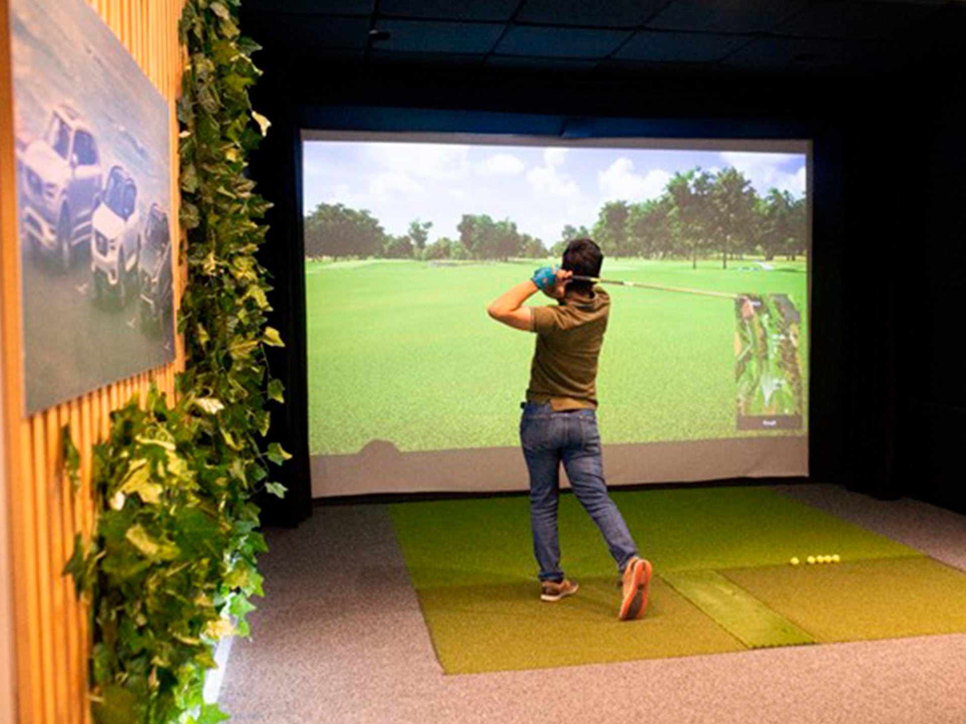 Una mujer jugando golf en un espacio cerrado.