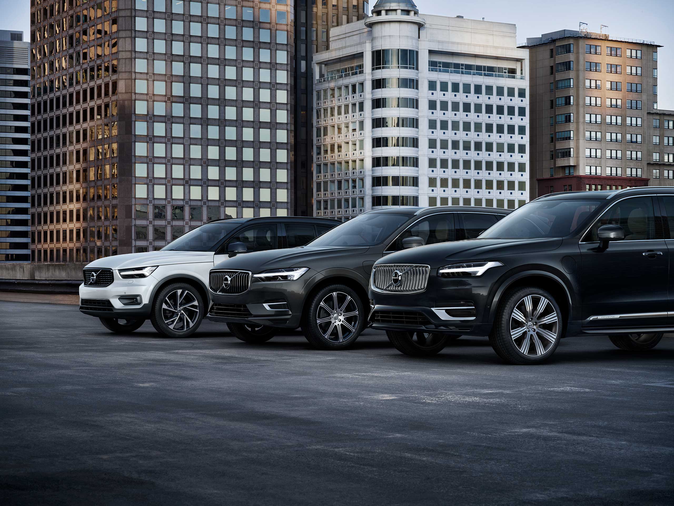Tre forskellige Volvo modeler i en parkeringsplads.