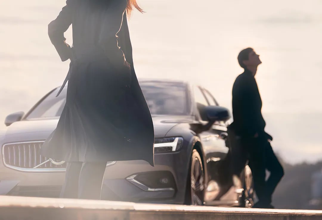 Figures of a man, woman and a car in sunset.