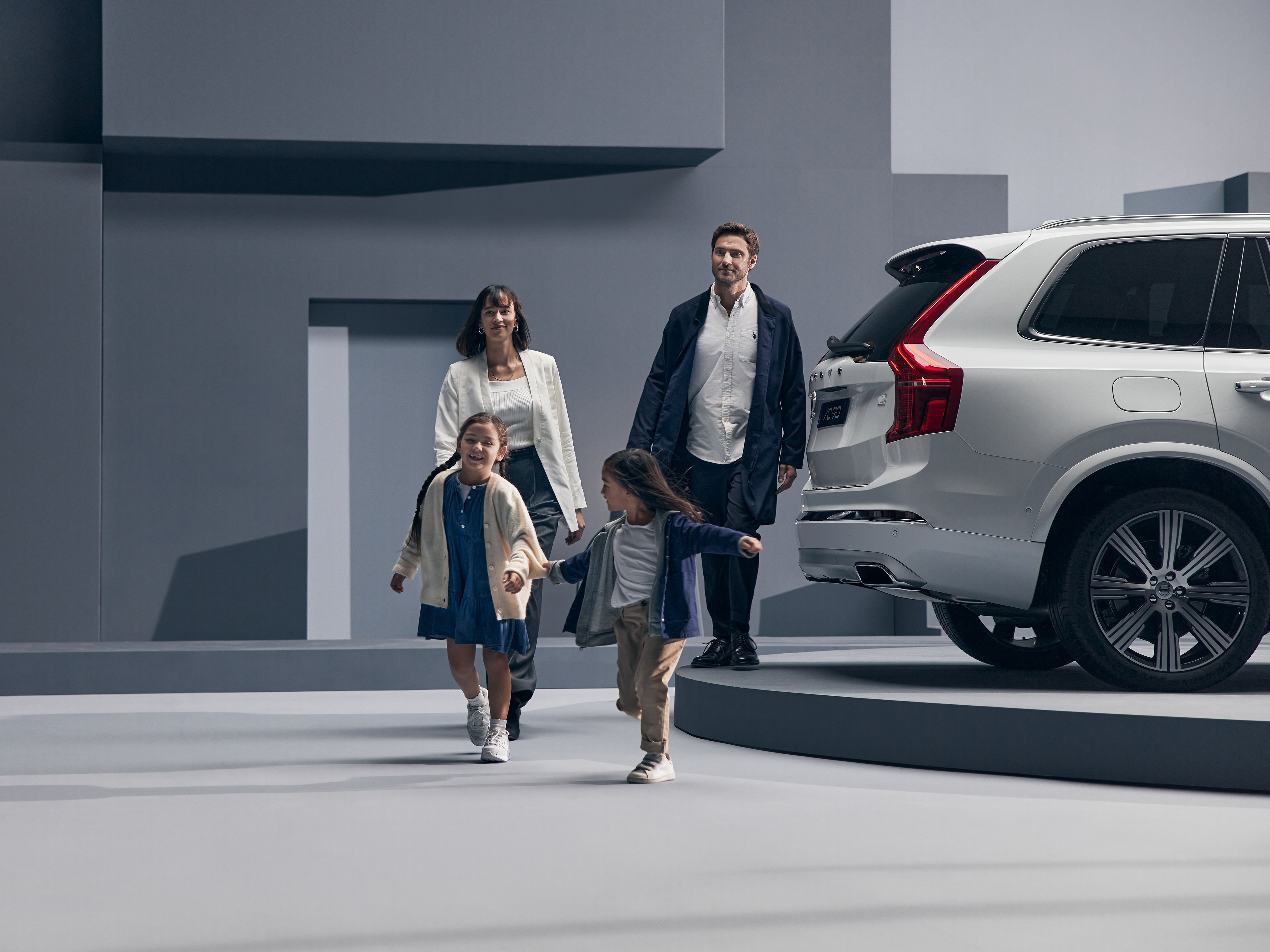 Famille marchant à coté d'une voiture Volvo