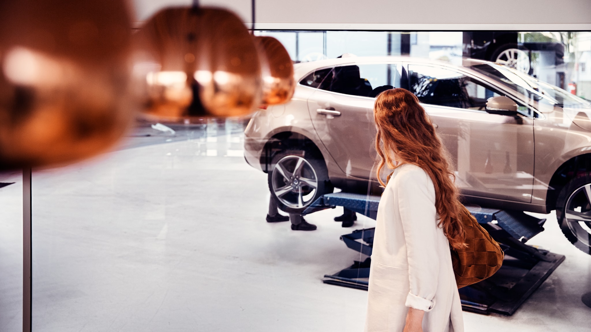 Femme près d'une voiture Volvo dans un garage 