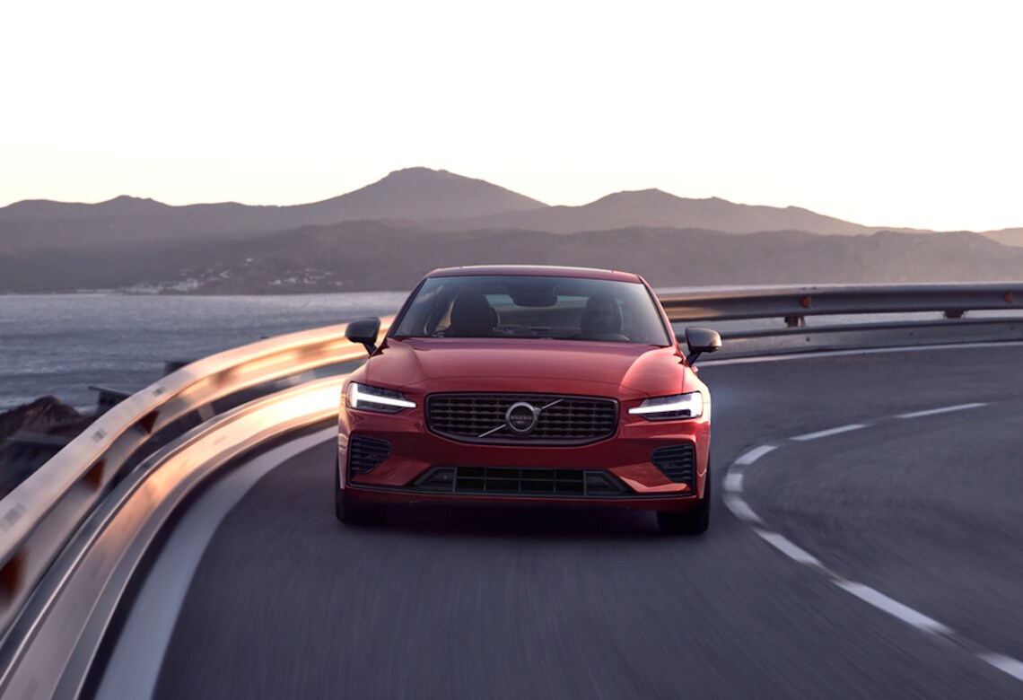 Volvo V60 in Fusion Red fährt durch eine Kurve - Frontschuss