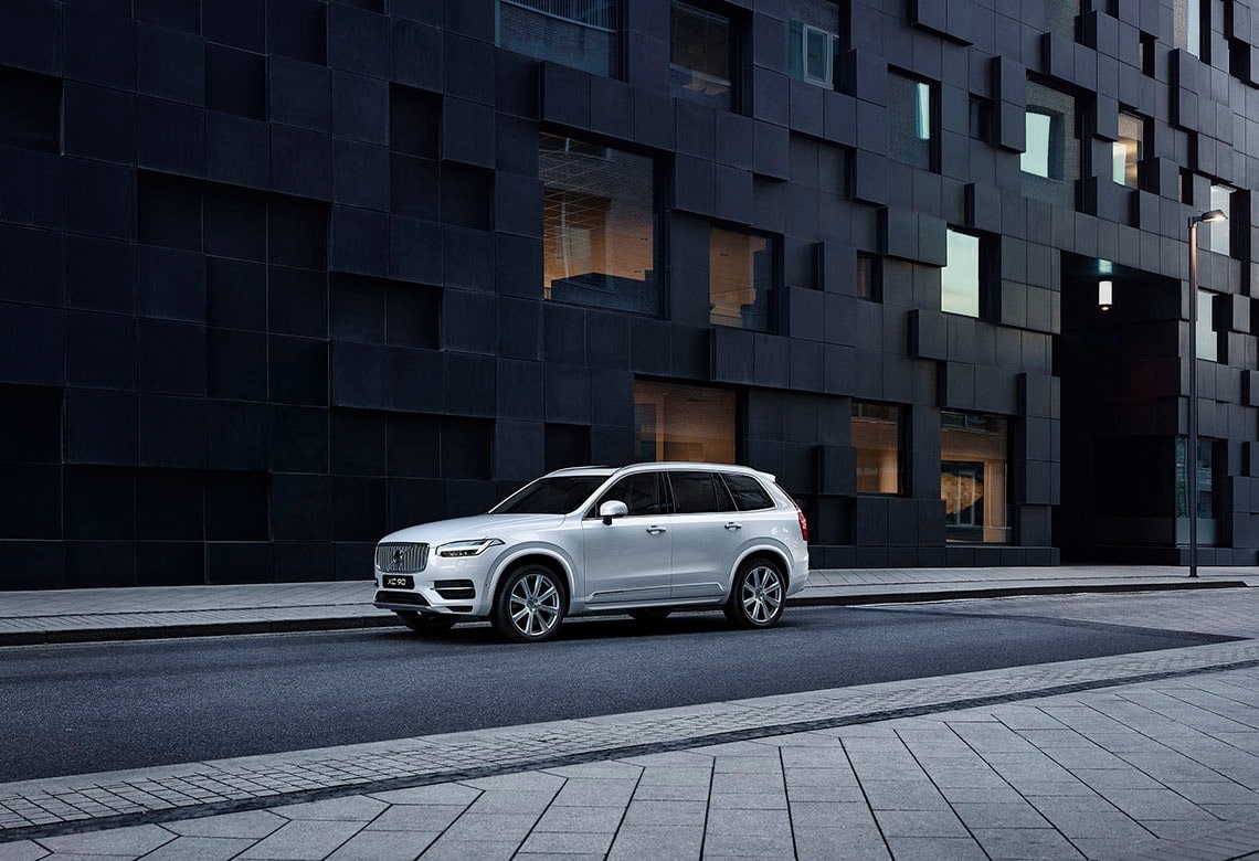 Volvo steht auf einer Straße neben einem schwarzen Gebäude  - Frontseitenschuss