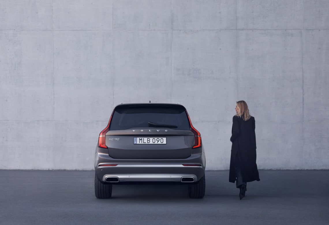 Frau steht neben einem Volvo XC90