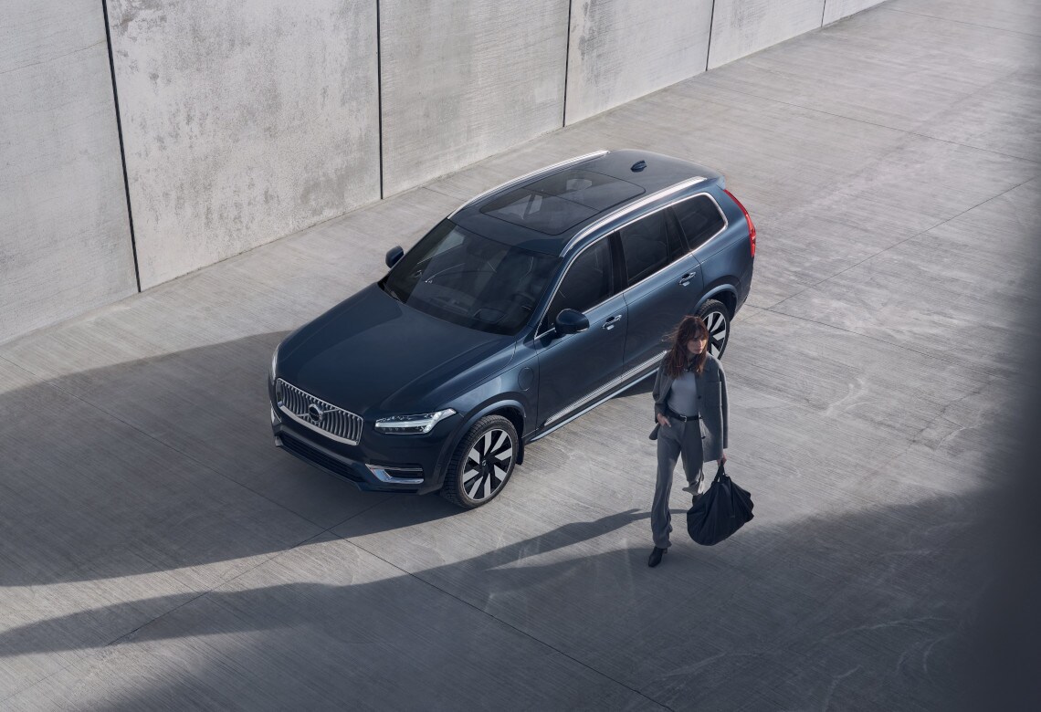 Eine Frau bewegt sich mit einer Tasche in der Hand von einem Volvo Fahrzeug weg