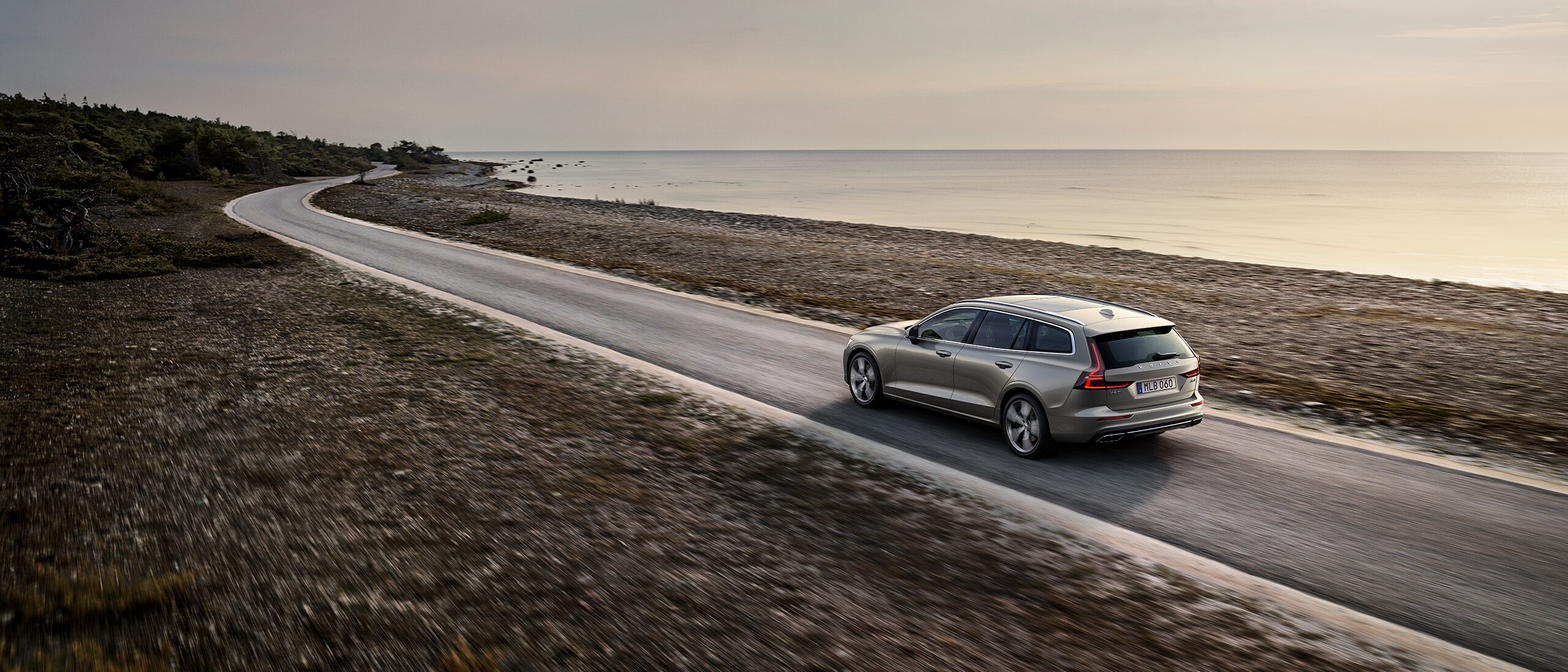 Volvo V60 halad az úton a tengerpart mellett.