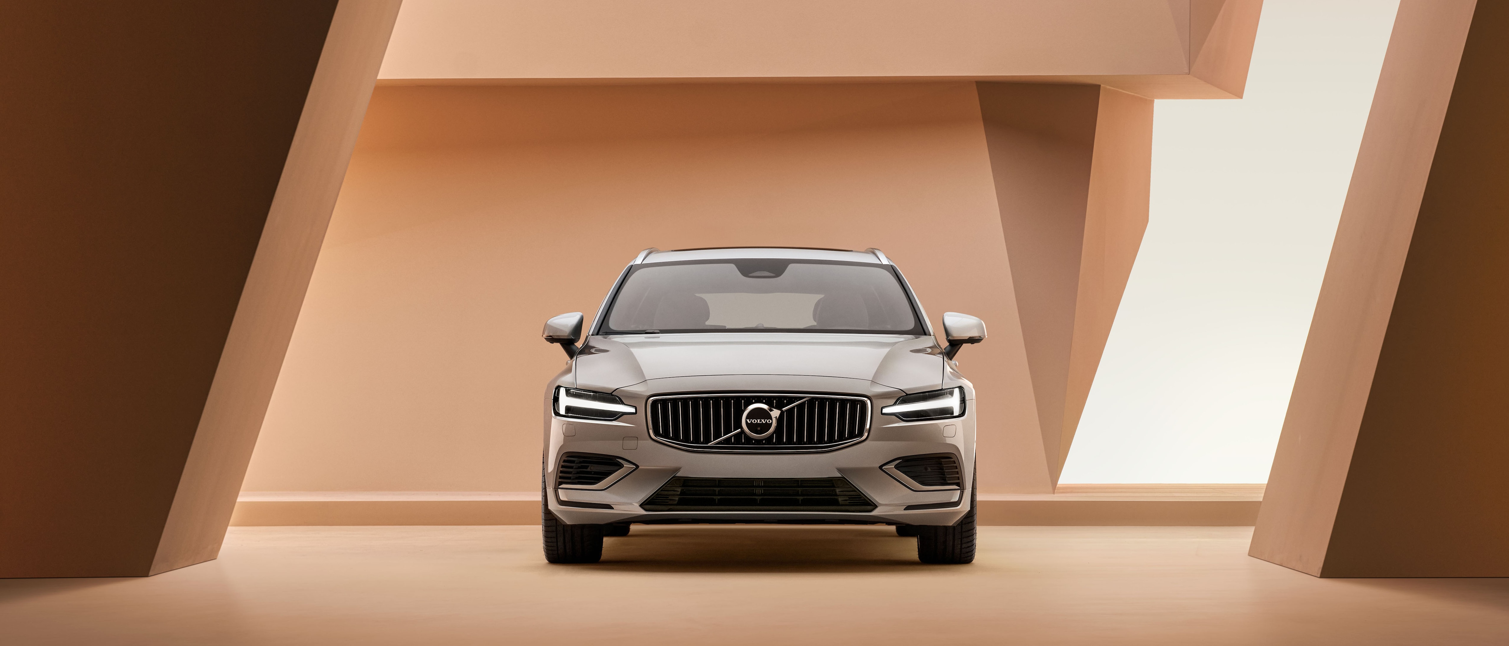 Grijze Volvo V60 Recharge in mooie architectonische ruimte.