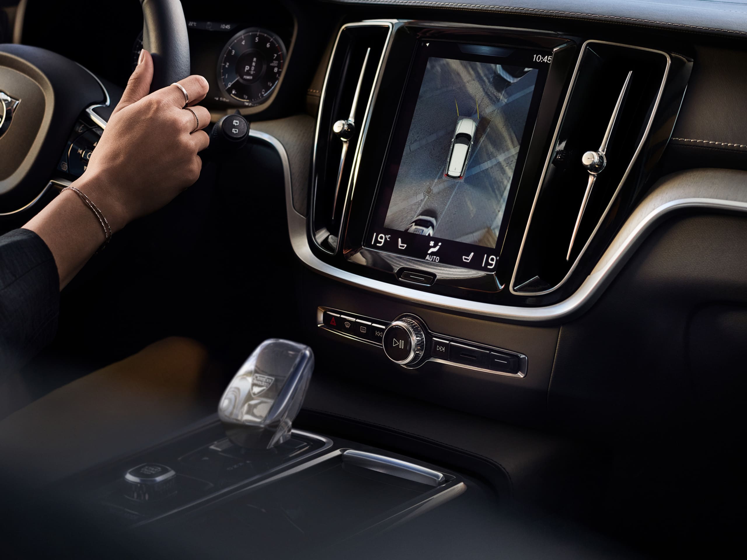 Interior de um automóvel conduzido pelas mãos de uma mulher, visíveis na imagem, onde se revelam também todos os pormenores de conforto e design deste modelo.