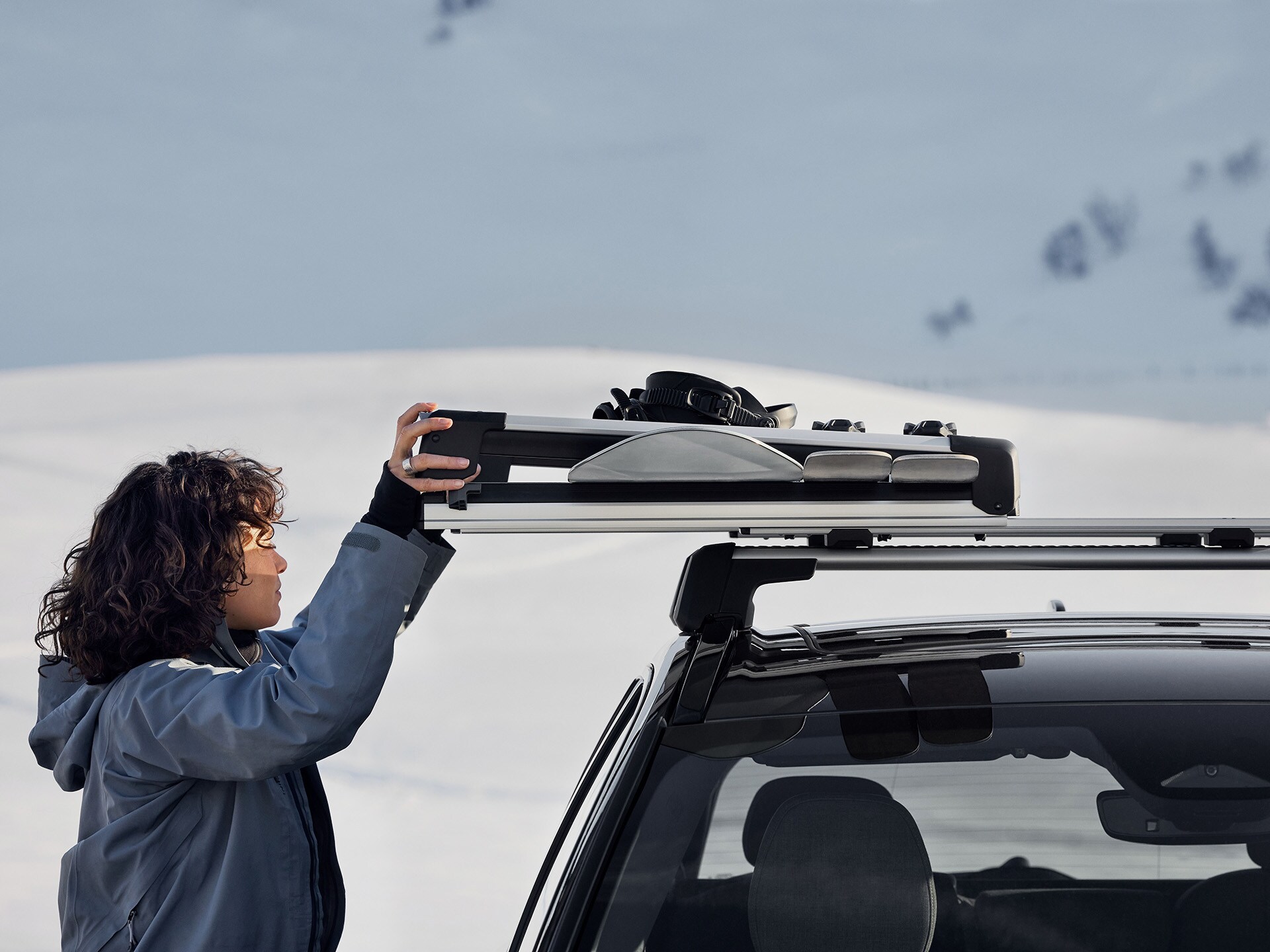 Una mujer colocando su equipo de esquí de un portaesquís Volvo
