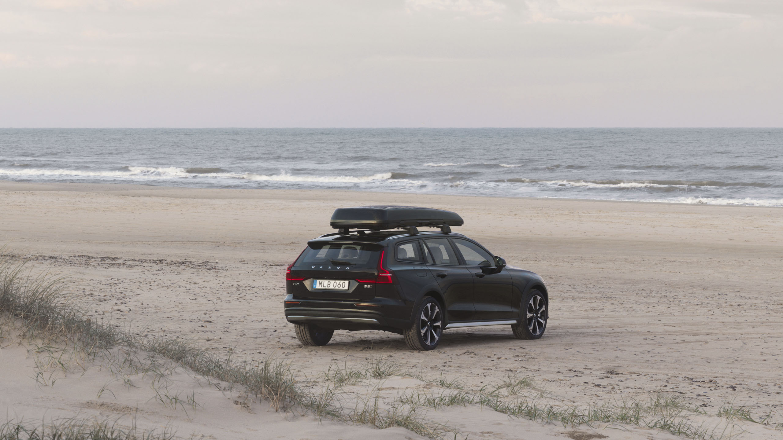 Volvo V60 con cofre de techo en una playa