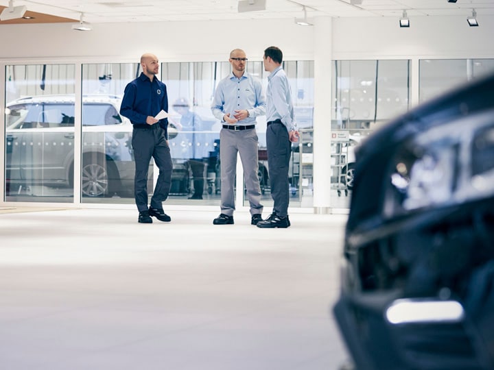 Mecánicos y clientes hablando en un taller concesionario Volvo