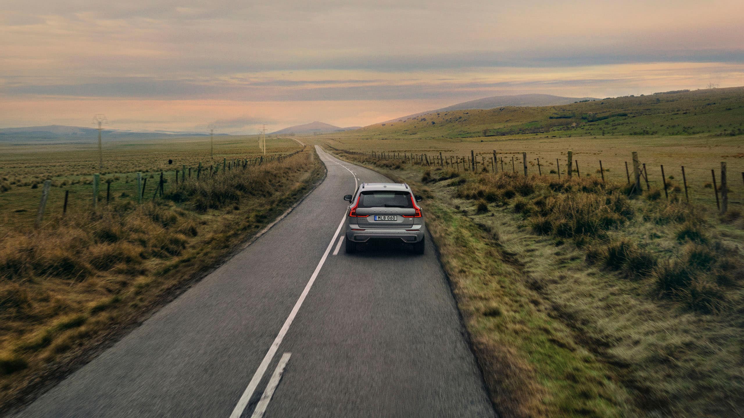 Un Volvo familiar viajando por una carretera en el campo