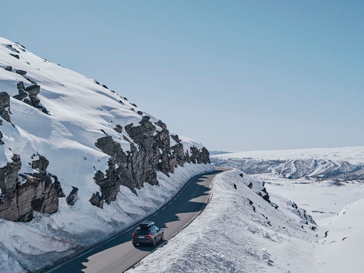 Un vehículo Volvo en medio de las montañas y la nieve