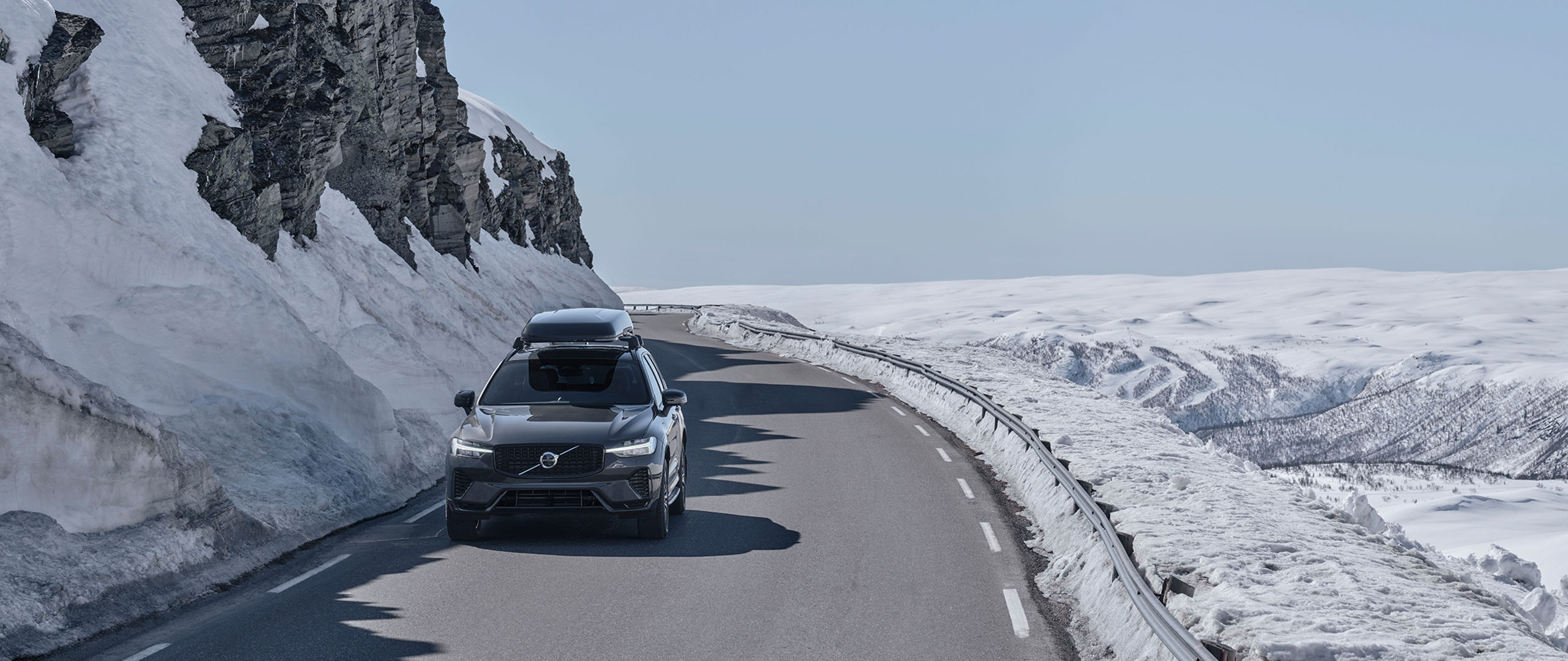 Grå Volvo kör i vinterlandskap