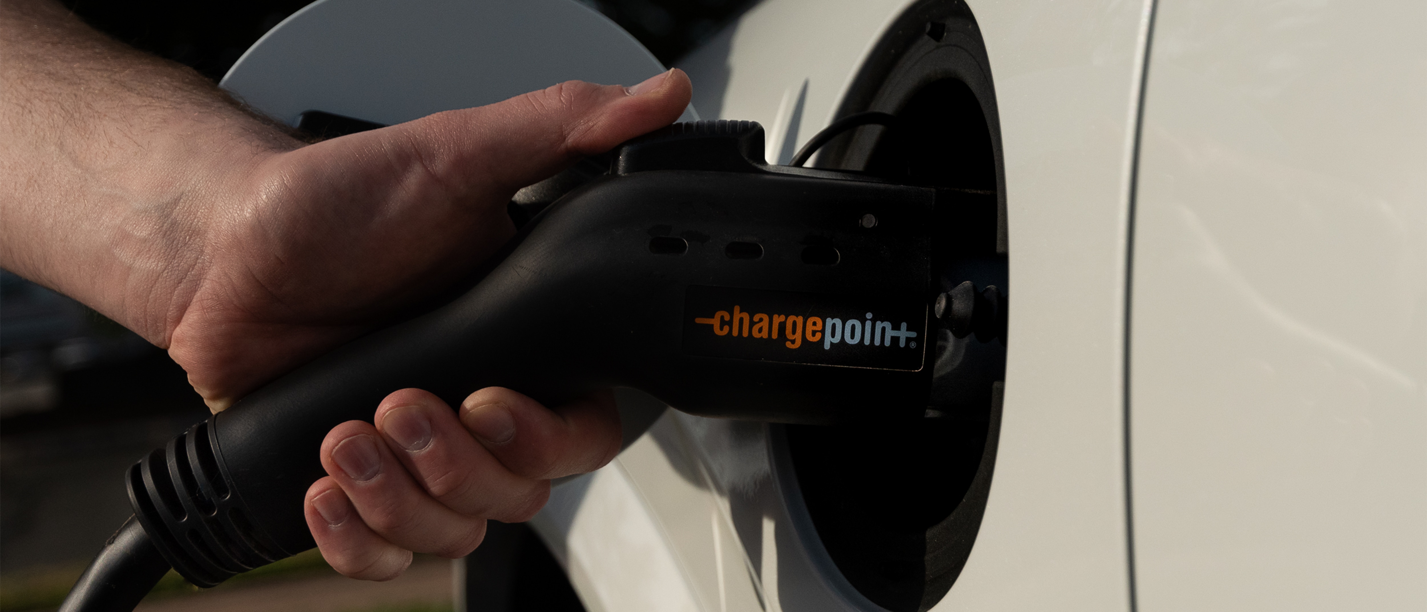 Mans hand charging Volvo with Chargepoint