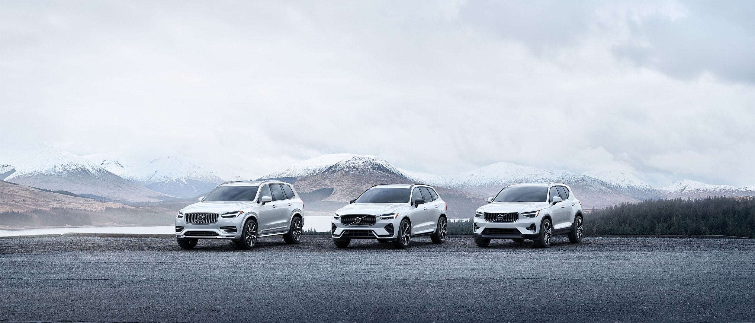 Volvo SUV Range parked in front of snowy mountain range