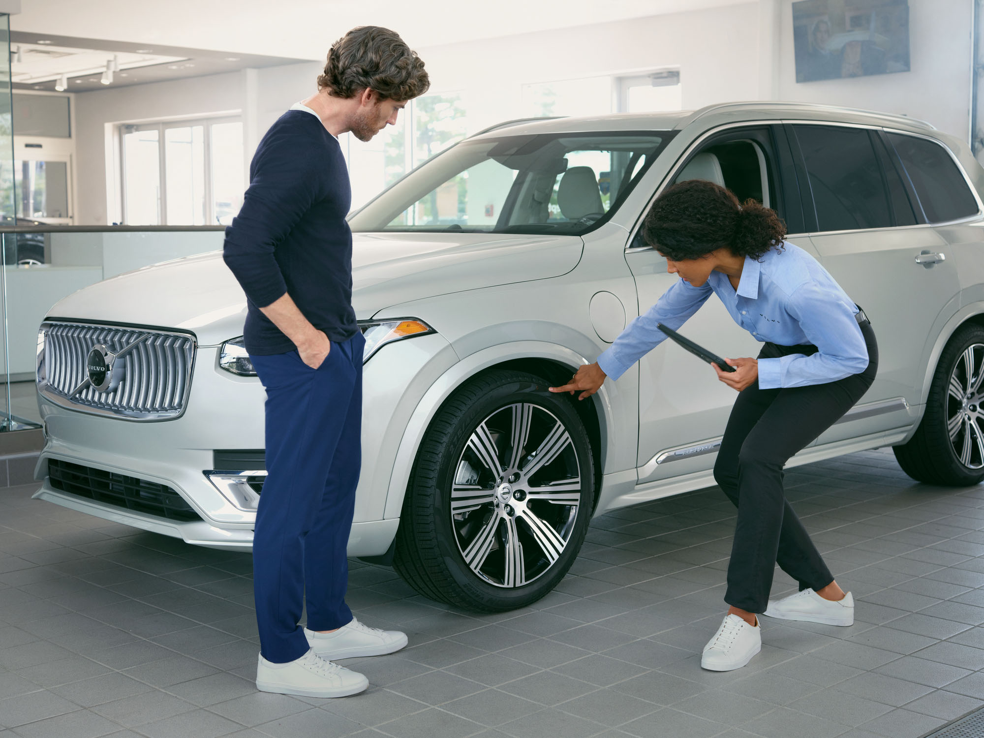 Volvo Protection Plans - technician inspecting tire with customer 