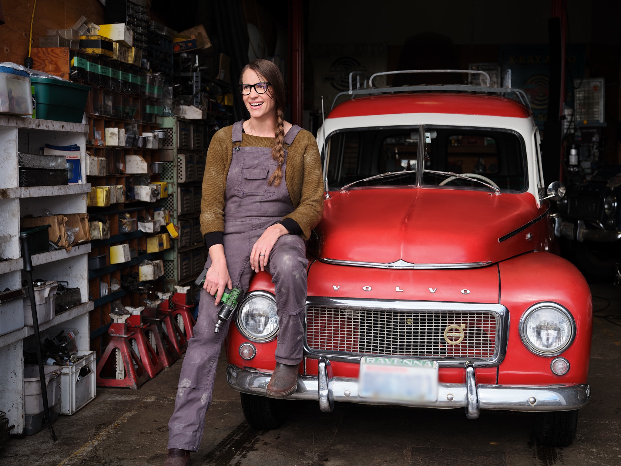 Woman in Overalls Sitting on Volvo - Volvo Women's Stories Amy N.
